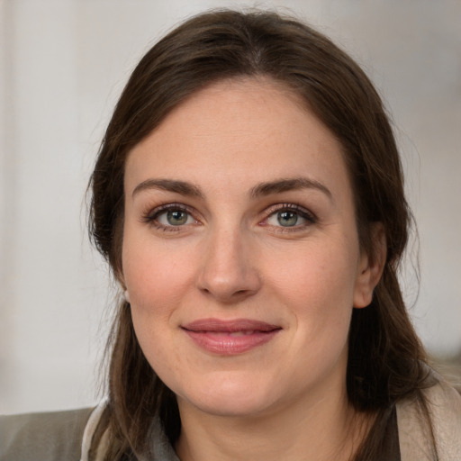 Joyful white young-adult female with long  brown hair and grey eyes