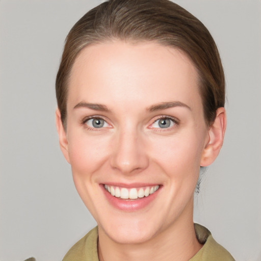 Joyful white young-adult female with short  brown hair and grey eyes