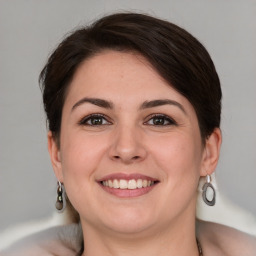 Joyful white young-adult female with medium  brown hair and grey eyes