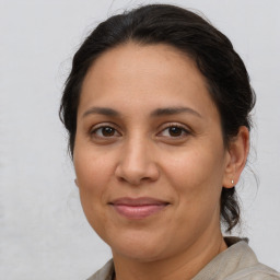 Joyful latino adult female with medium  brown hair and brown eyes