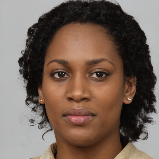 Joyful black young-adult female with long  black hair and brown eyes