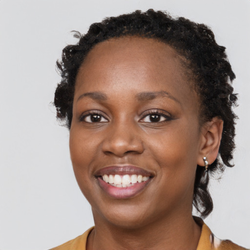 Joyful black young-adult female with short  brown hair and brown eyes