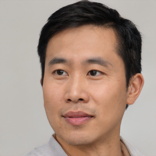 Joyful asian young-adult male with short  black hair and brown eyes