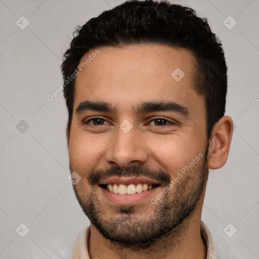 Joyful white young-adult male with short  black hair and brown eyes