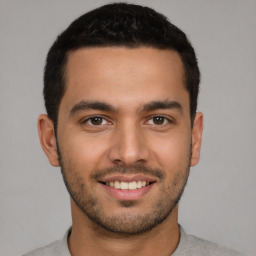 Joyful latino young-adult male with short  brown hair and brown eyes