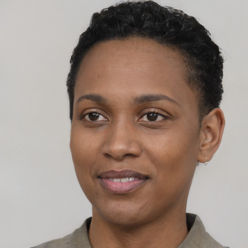 Joyful black young-adult female with short  black hair and brown eyes