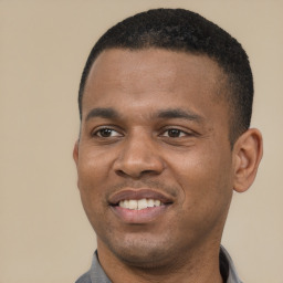 Joyful black young-adult male with short  black hair and brown eyes