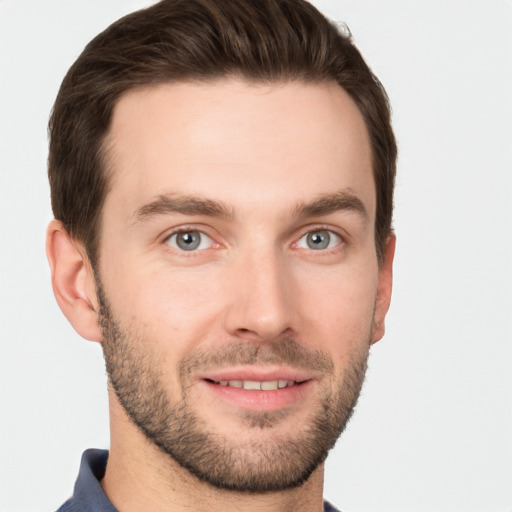 Joyful white young-adult male with short  brown hair and grey eyes