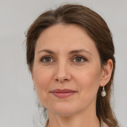 Joyful white adult female with medium  brown hair and grey eyes