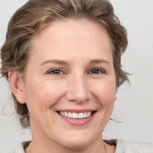 Joyful white young-adult female with medium  brown hair and blue eyes