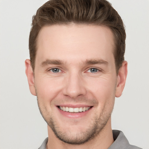 Joyful white young-adult male with short  brown hair and grey eyes