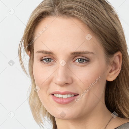 Joyful white young-adult female with long  brown hair and blue eyes