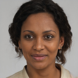 Joyful black adult female with medium  brown hair and brown eyes