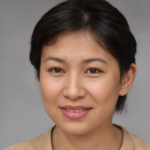 Joyful asian adult female with medium  brown hair and brown eyes