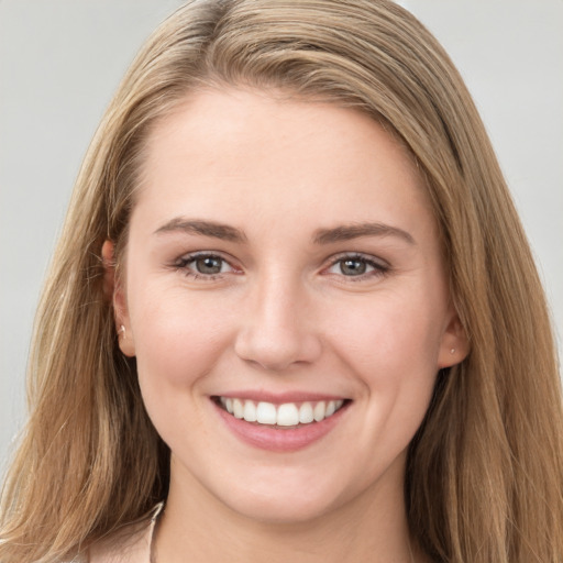 Joyful white young-adult female with long  brown hair and grey eyes