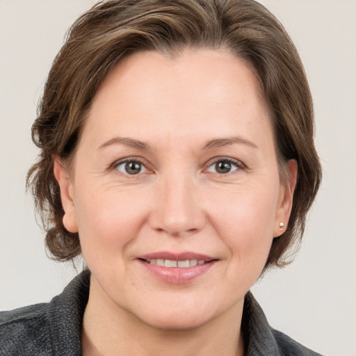 Joyful white adult female with medium  brown hair and grey eyes