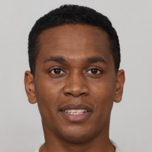 Joyful black young-adult male with short  brown hair and brown eyes