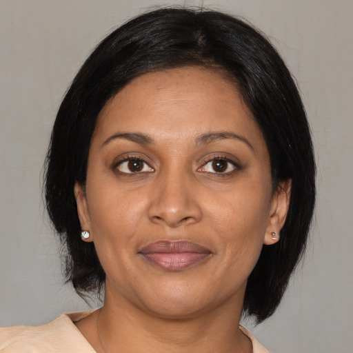 Joyful black adult female with medium  brown hair and brown eyes