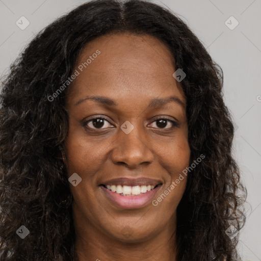 Joyful black young-adult female with long  brown hair and brown eyes