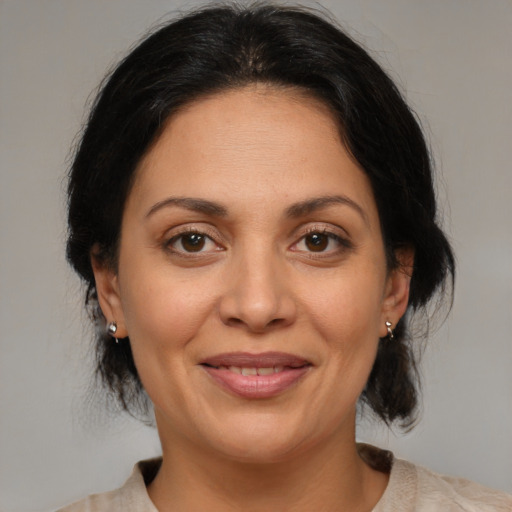 Joyful latino adult female with medium  brown hair and brown eyes