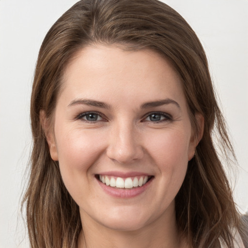 Joyful white young-adult female with long  brown hair and grey eyes