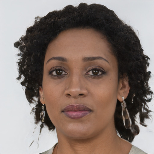 Joyful black young-adult female with long  brown hair and brown eyes