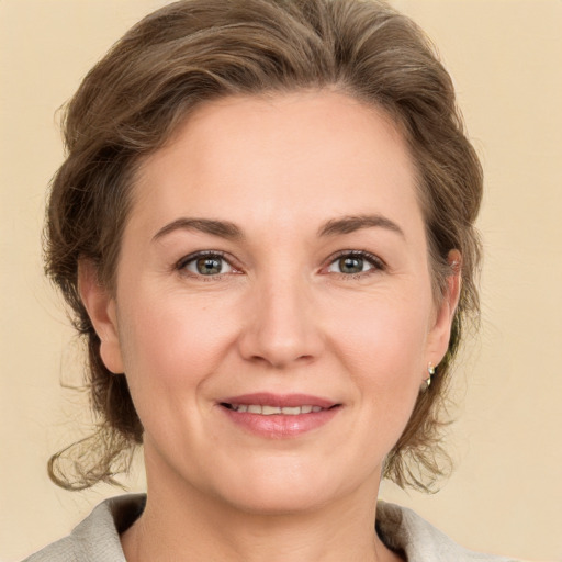 Joyful white adult female with medium  brown hair and grey eyes