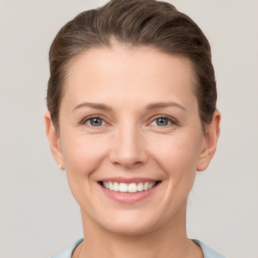 Joyful white young-adult female with short  brown hair and grey eyes