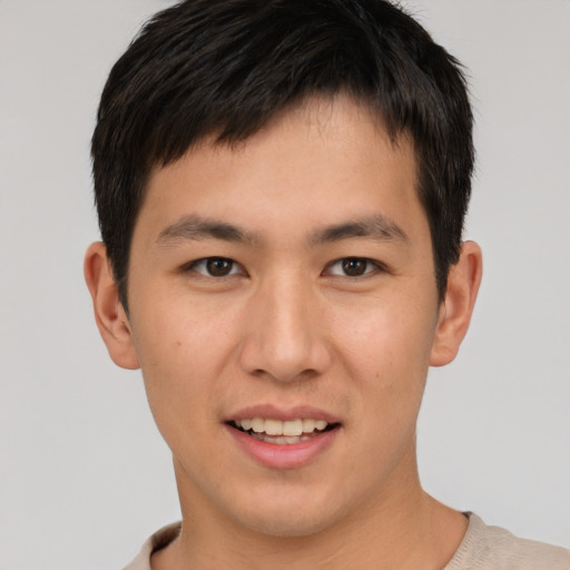 Joyful asian young-adult male with short  brown hair and brown eyes