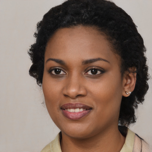Joyful black young-adult female with long  black hair and brown eyes