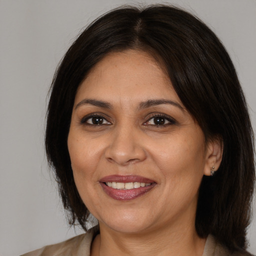 Joyful white adult female with medium  brown hair and brown eyes