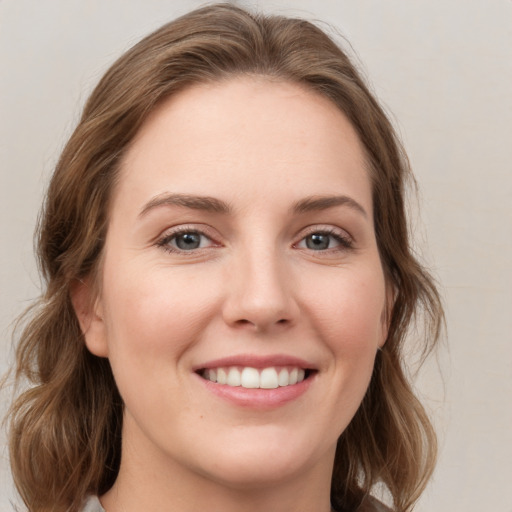 Joyful white young-adult female with medium  brown hair and green eyes