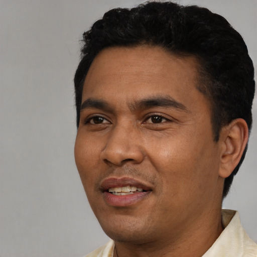 Joyful latino young-adult male with short  black hair and brown eyes