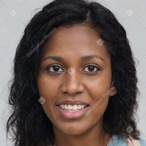 Joyful black young-adult female with long  brown hair and brown eyes