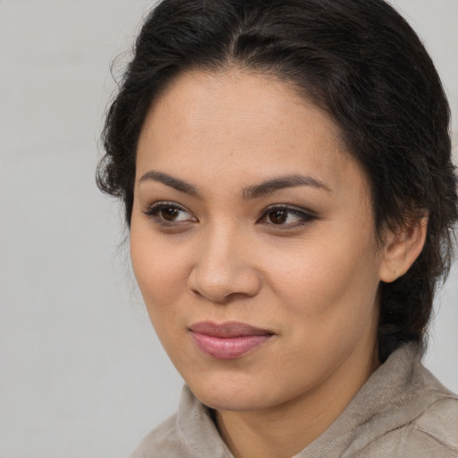 Joyful latino young-adult female with medium  brown hair and brown eyes