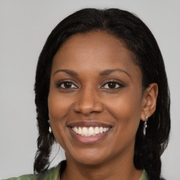 Joyful black young-adult female with long  brown hair and brown eyes