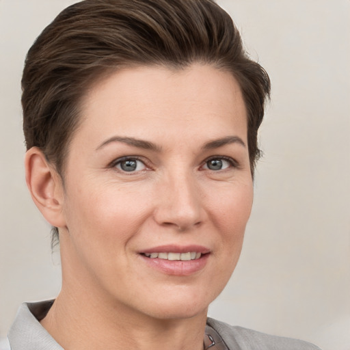 Joyful white young-adult female with short  brown hair and grey eyes