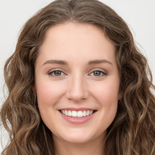 Joyful white young-adult female with long  brown hair and green eyes