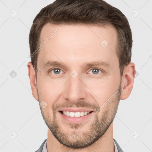 Joyful white young-adult male with short  brown hair and grey eyes