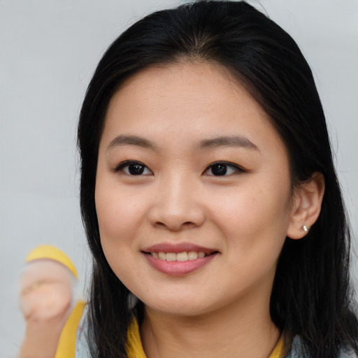 Joyful asian young-adult female with long  brown hair and brown eyes