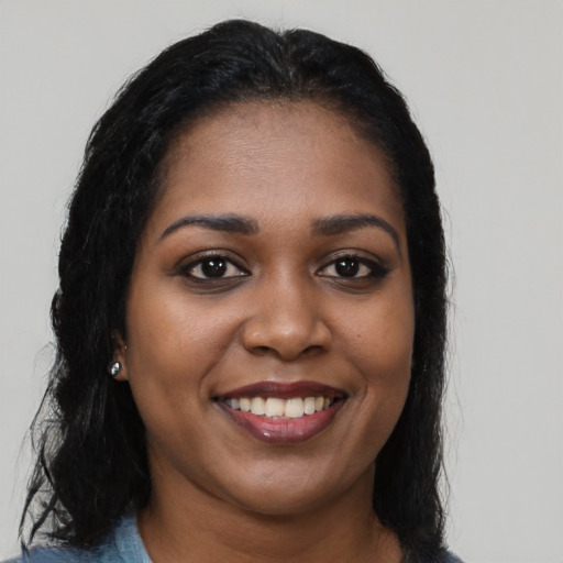 Joyful black young-adult female with long  black hair and brown eyes