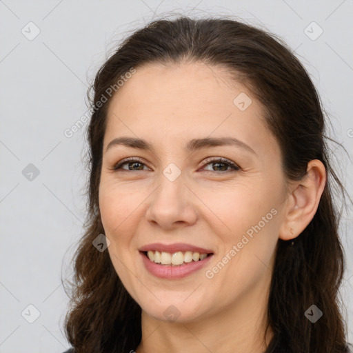 Joyful white young-adult female with long  brown hair and brown eyes