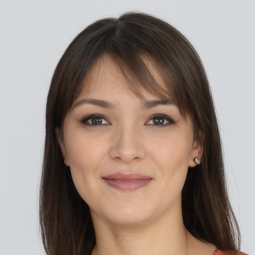 Joyful white young-adult female with long  brown hair and brown eyes