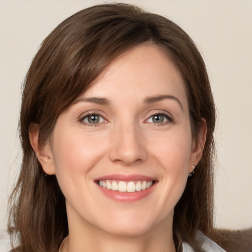 Joyful white young-adult female with medium  brown hair and grey eyes