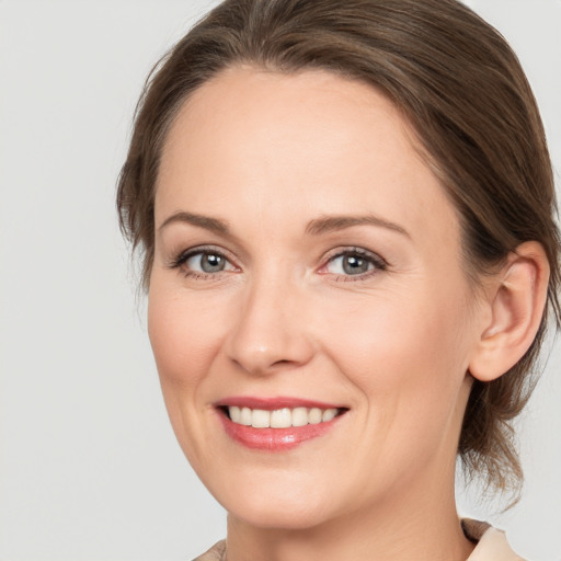 Joyful white adult female with medium  brown hair and grey eyes