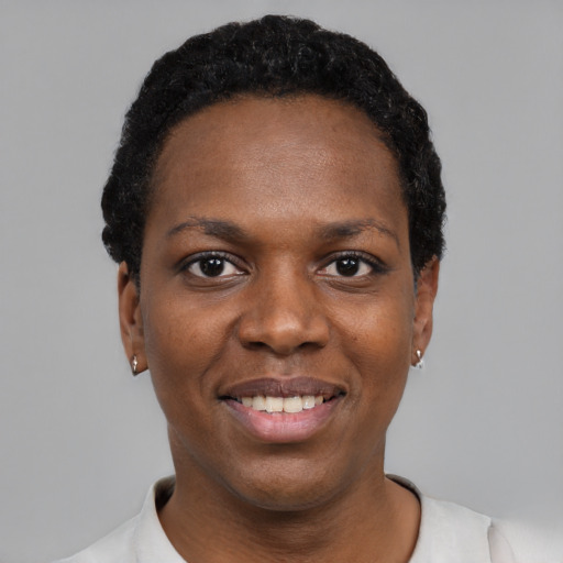 Joyful black young-adult female with short  black hair and brown eyes