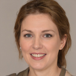 Joyful white young-adult female with medium  brown hair and grey eyes