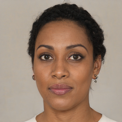 Joyful black young-adult female with short  black hair and brown eyes
