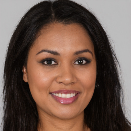 Joyful latino young-adult female with long  brown hair and brown eyes