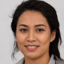 Joyful latino young-adult female with medium  brown hair and brown eyes